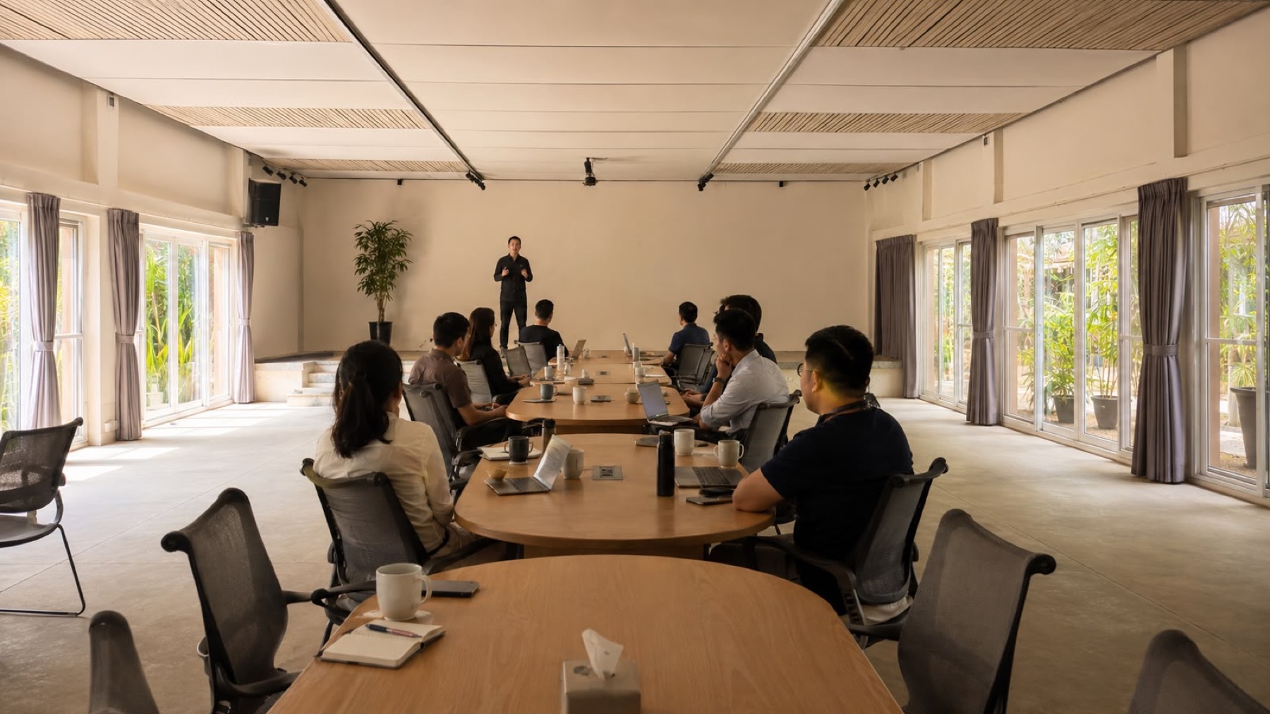 A team seated in Gulmohar Hall at Orchid Tree during a working session, a presenter at the screen
